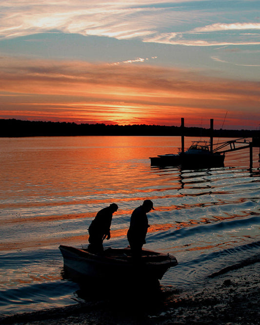 two men in a boat at sunset photograph